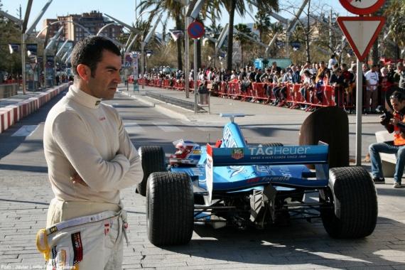 Jordi Gené junto al Benetton de F1 con el público espectante al fondo. 