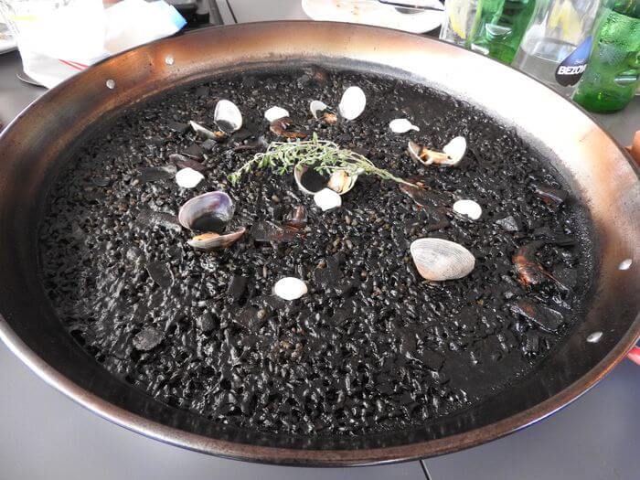 Arroz negro con almejas y alioli de hierbas