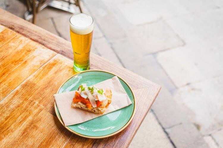 Rossini – Pan de coca con escalivada y bacalao confitado al ajo.